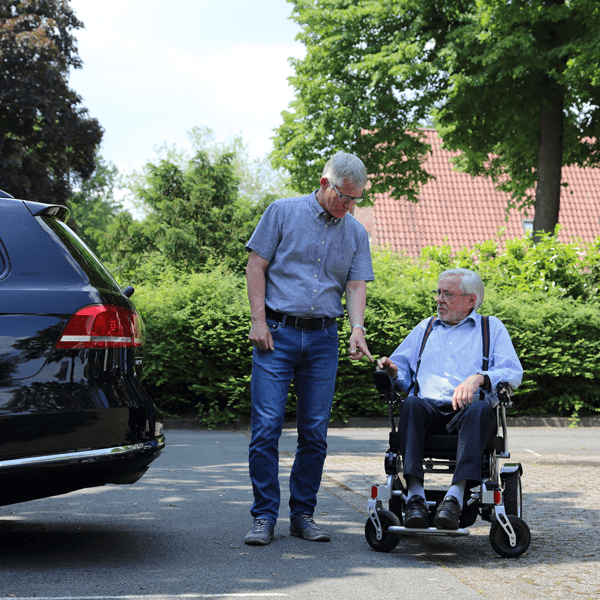 Elektrorollstuhl im Straßenverkehr Mann mit älteren Mann im Rollstuhl