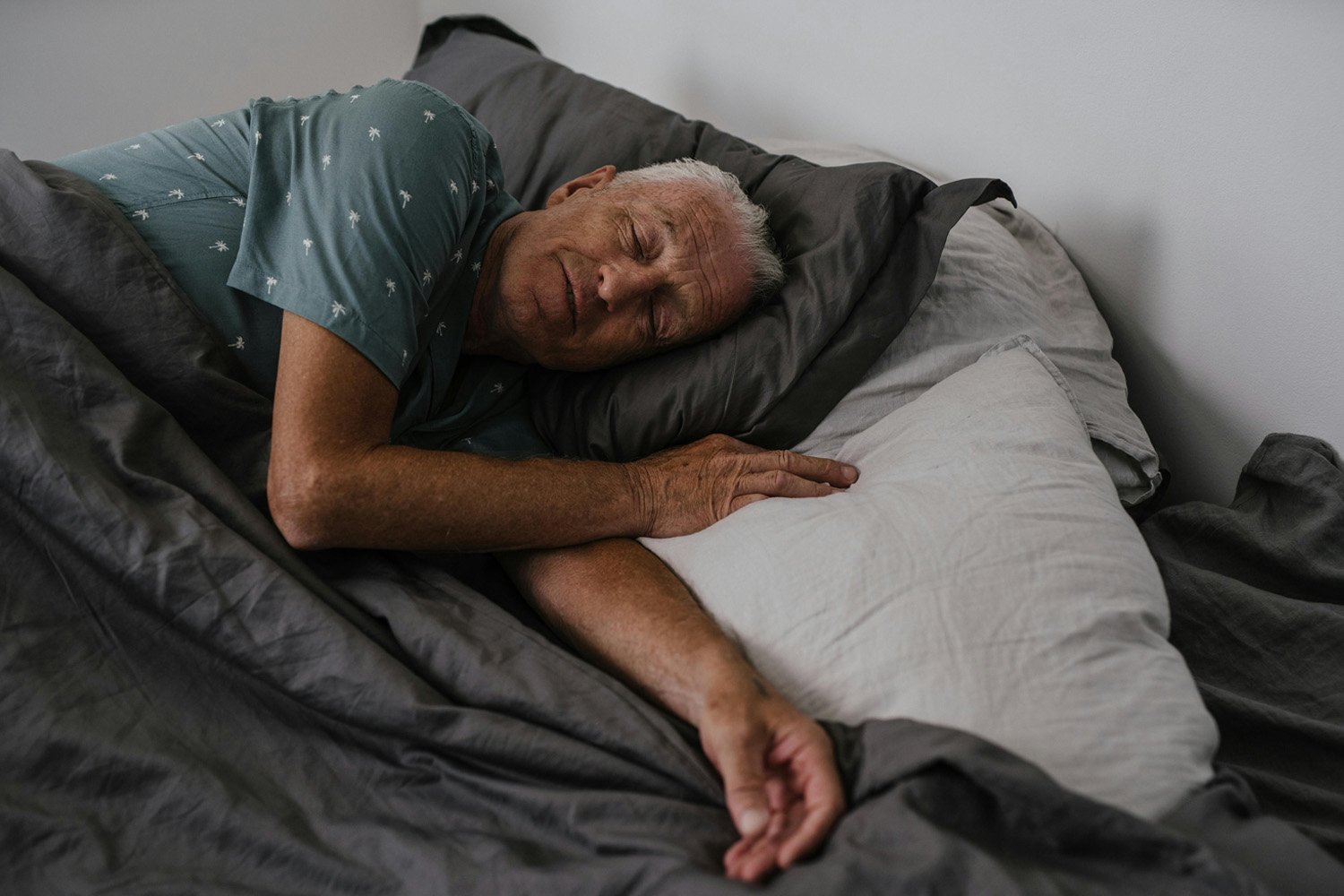 Das Bild zeigt einen Mann, der im Bett liegt