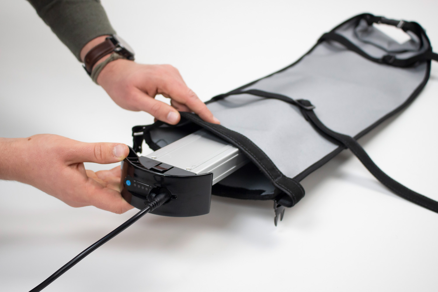 Das Bild zeigt, wie der Akku eines Elektrorollstuhls gerade in der Akku-Sicherheitstasche von ergoflix verstaut wird.