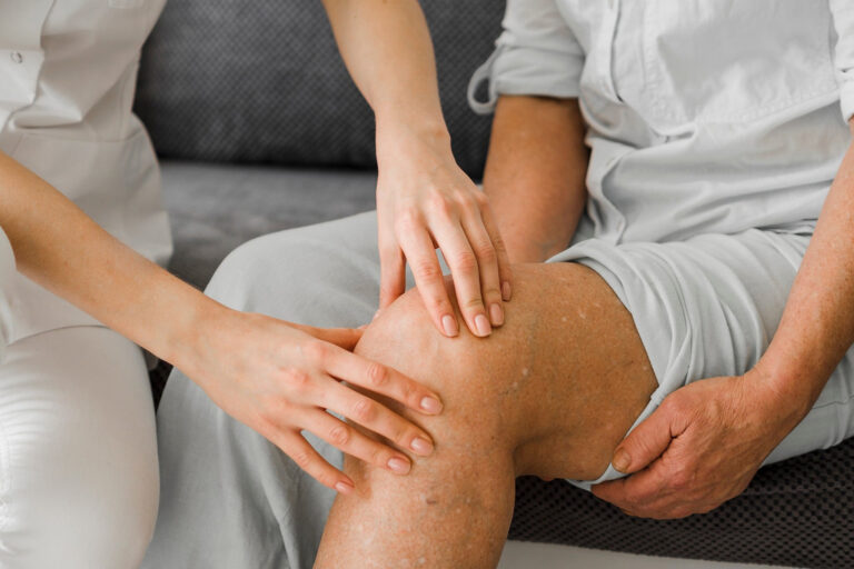 Das Bild zeigt den Unterk&ouml;rper eines Mannes, w&auml;hrend ein Arzt sein Knie abtastet.