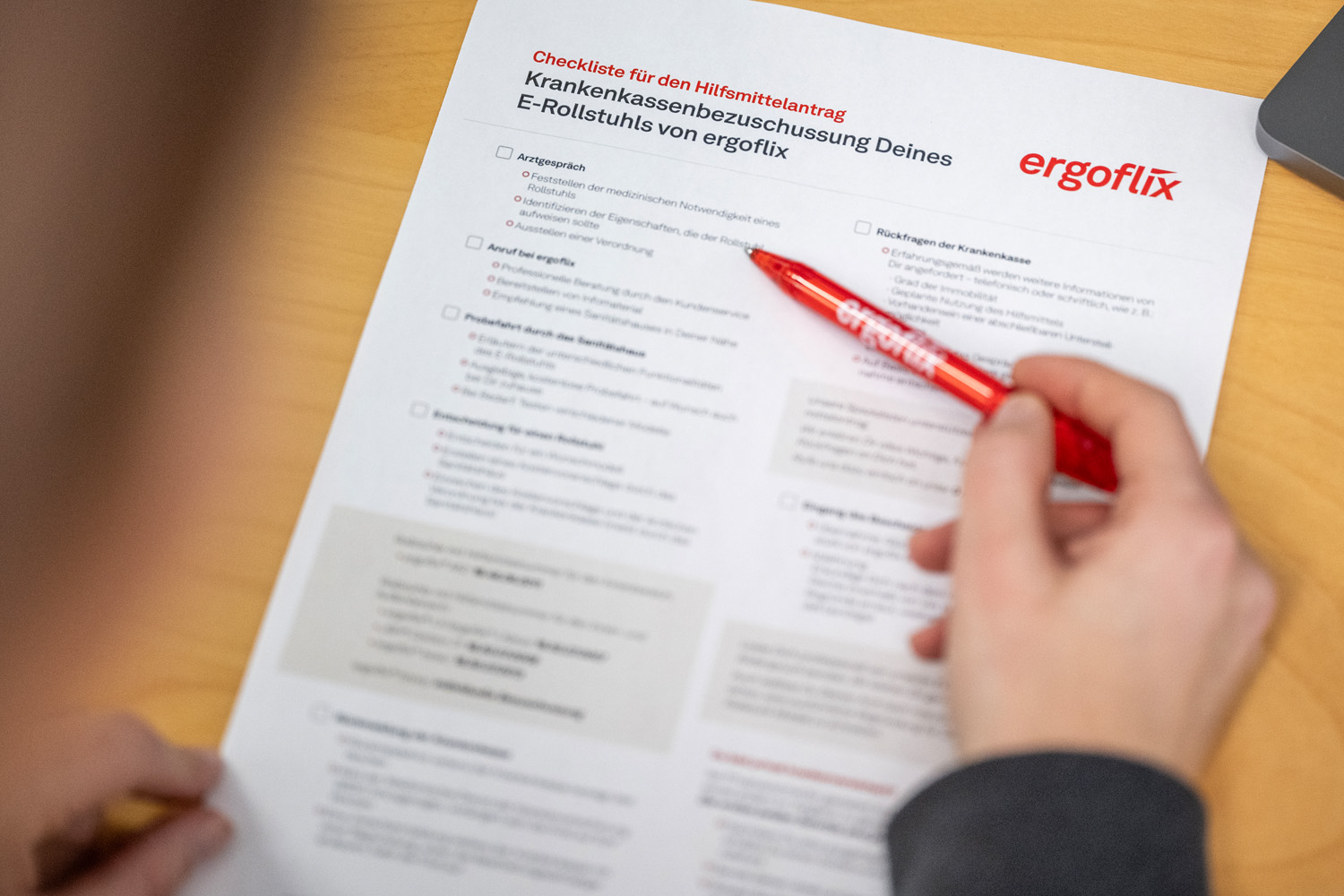 Das Bild zeigt ein Formular mit einer Checkliste, die bei einem Hilfsmittelantrag für einen Rollstuhl zu beachten ist.