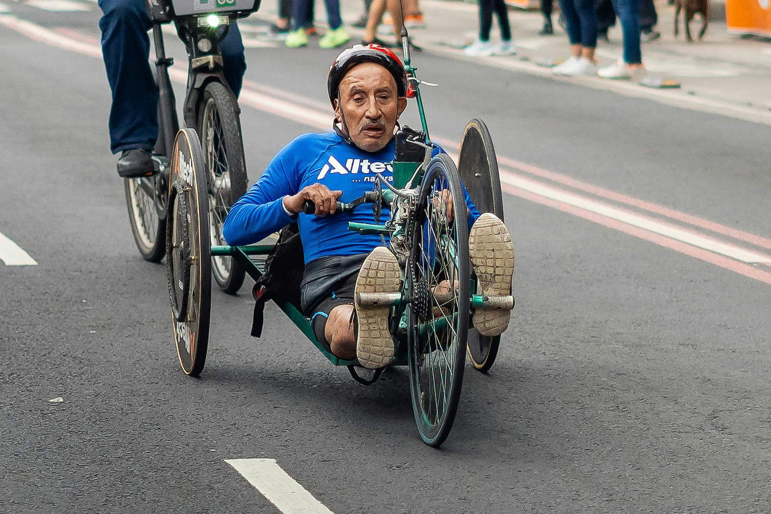Ein Mann fährt mit einem Handbike die Straße entlang.