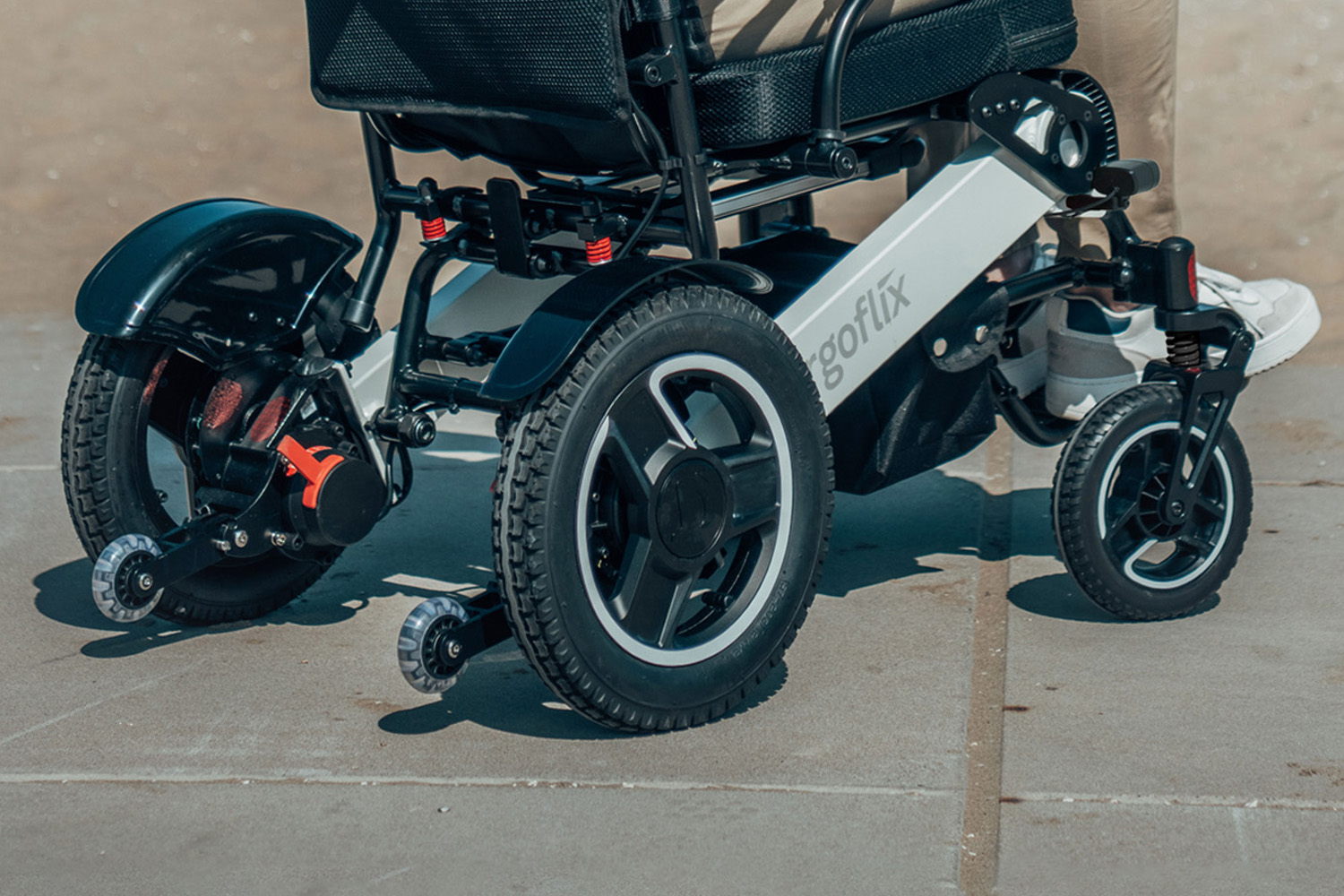 Das Foto zeigt einen ergoflix-Rollstuhl von hinten, an dem Kippschutzräder angebracht sind.