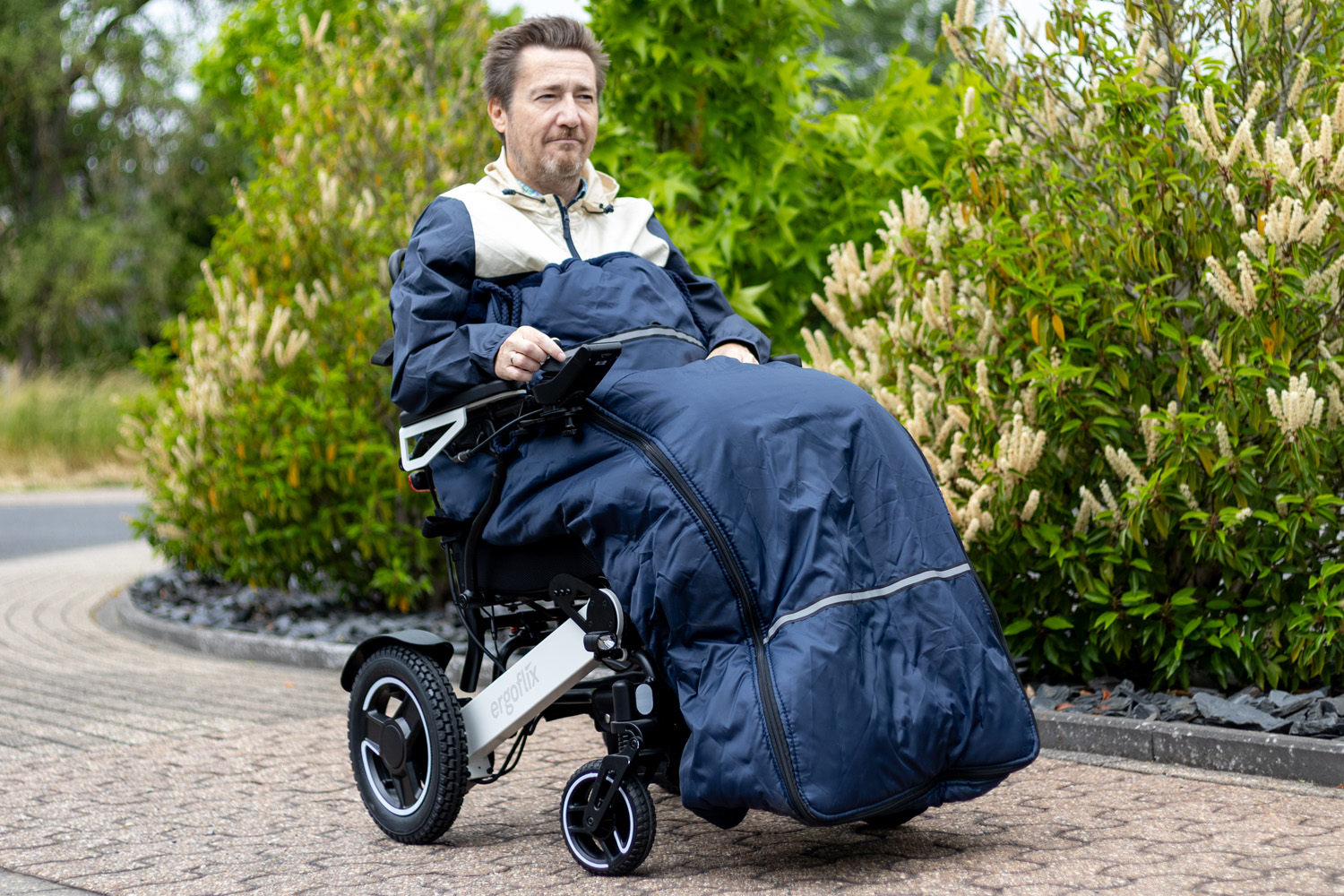 Das Bild zeigt einen Mann im Rollstuhl, der einen Schlupfsack trägt, um sich vor Kälte zu schützen.