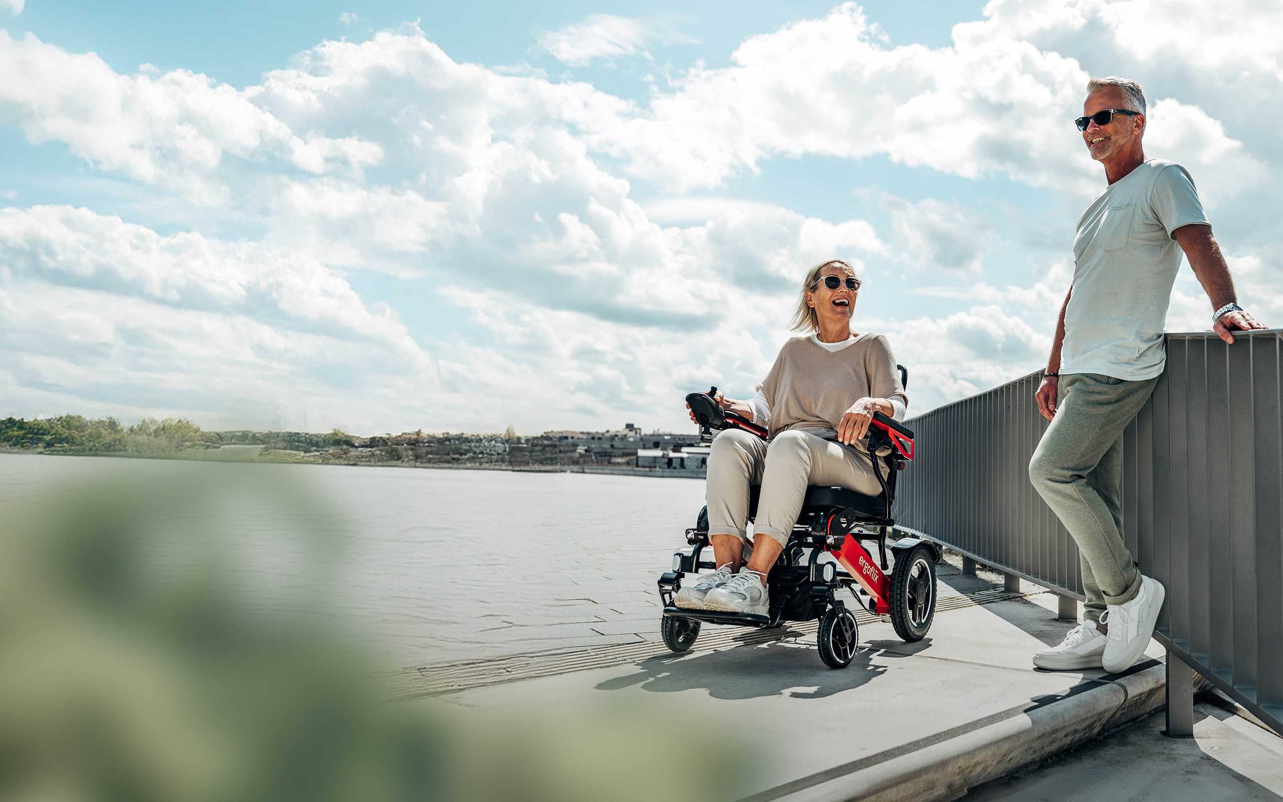 Frau f&auml;hrt den ergoflix LX an der Uferpromenade, ihr Begleiter daneben