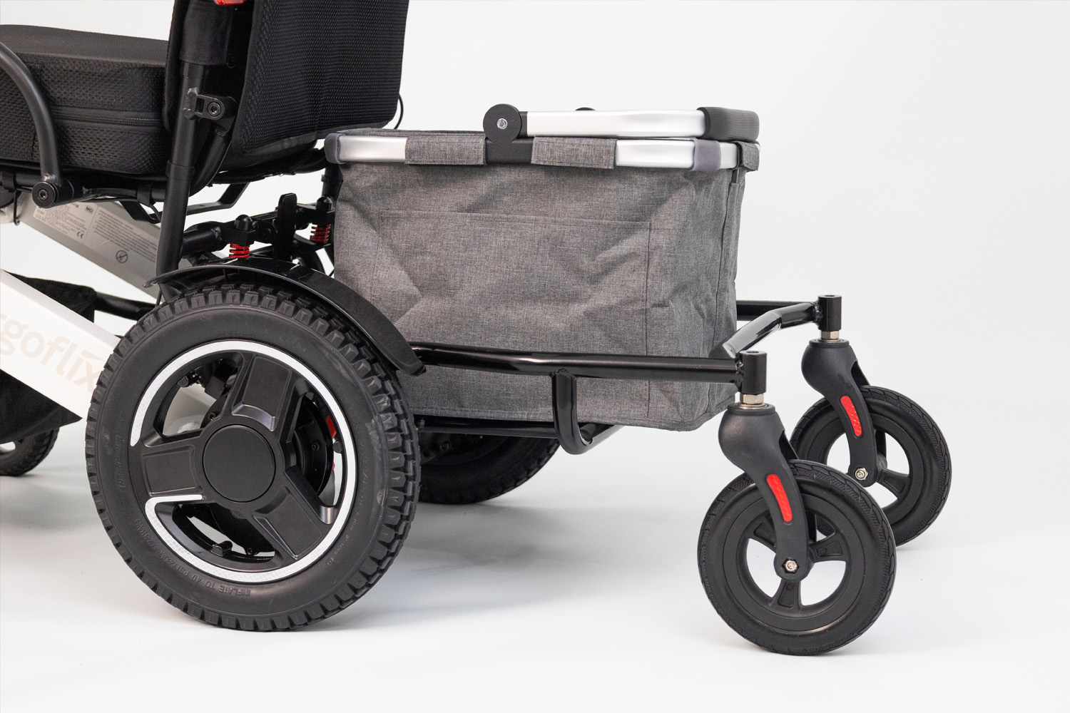 Das Bild zeigt eine Nahaufnahme eines Rollstuhl-Anhängers mit einem Einkaufskorb darin.