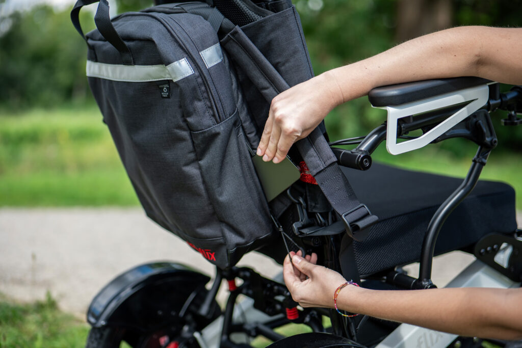 Das Bild zeigt den Rollstuhlrucksack, der hinten an der Rollstuhllehne des ergoflix LX angebracht ist.