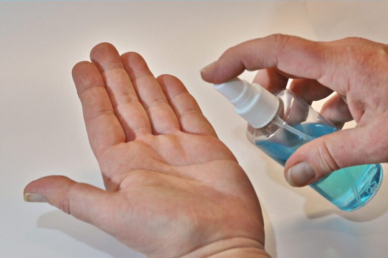 Dieses Bild zeigt eine Hand, auf die Desinfektionsmittel gespr&uuml;ht wird