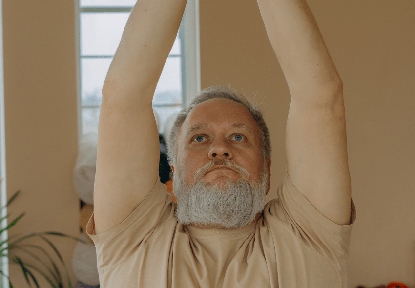 Dieses Bild zeigt einen Mann, der Sitzgymnastik für Senioren macht