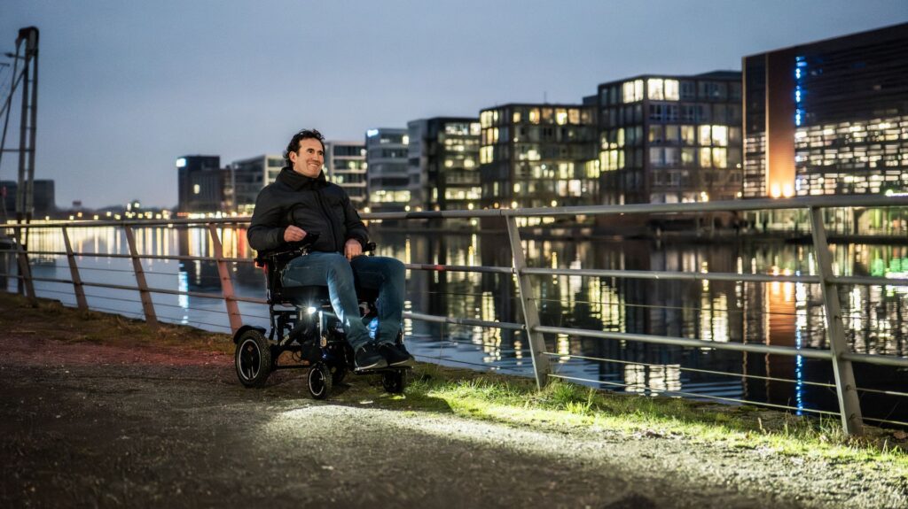 Ein Mann fährt abends in der Dämmerung an einer Promenade mit dem ergoflix® Carbon.