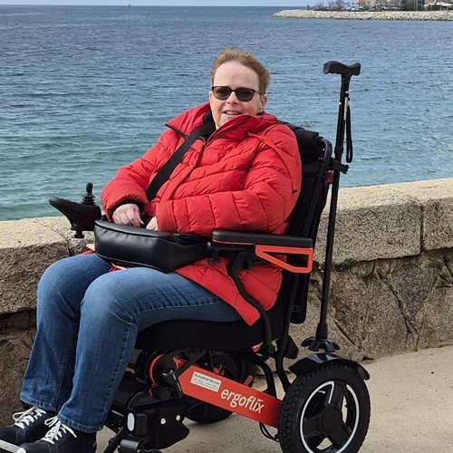 Kundin Astrid in ihrem roten ergoflix® LX an einer Uferpromenade