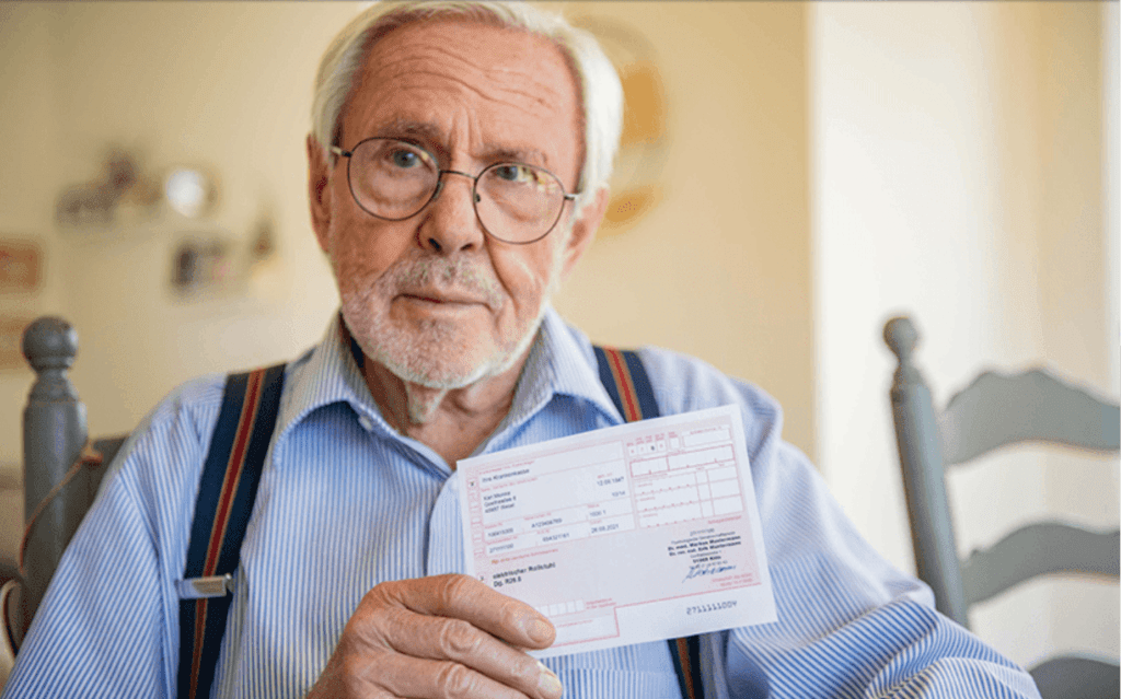 Was sind Hilfsmittelnummern? Dieses Bild zeigt einen Mann, der ein Rezept vom Arzt hält.