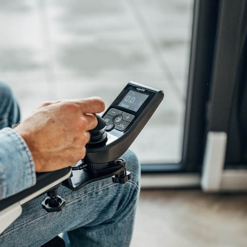 Hand am Joystick des Bedienmoduls eines ergoflix vario